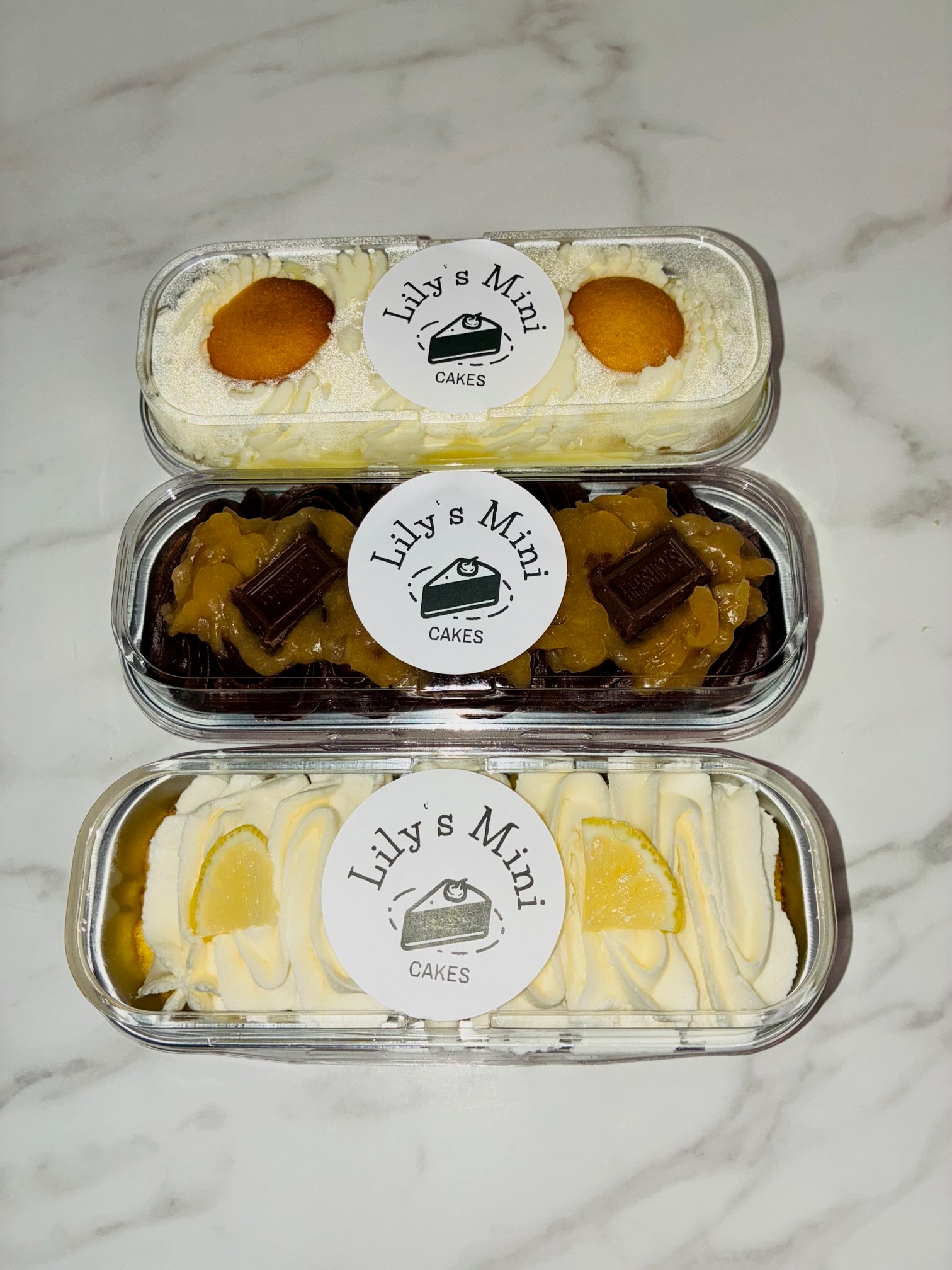 Lily's Mini Cakes — three varieties in clear containers with branded stickers